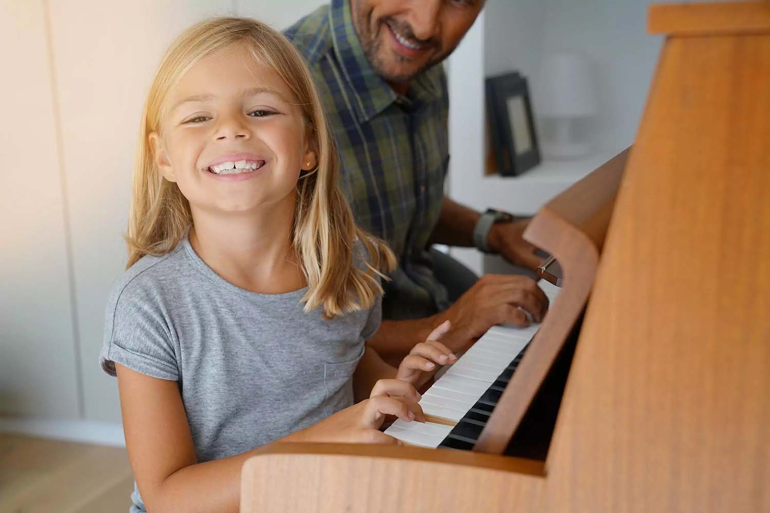 Padre enseña a su hija a tocar el piano